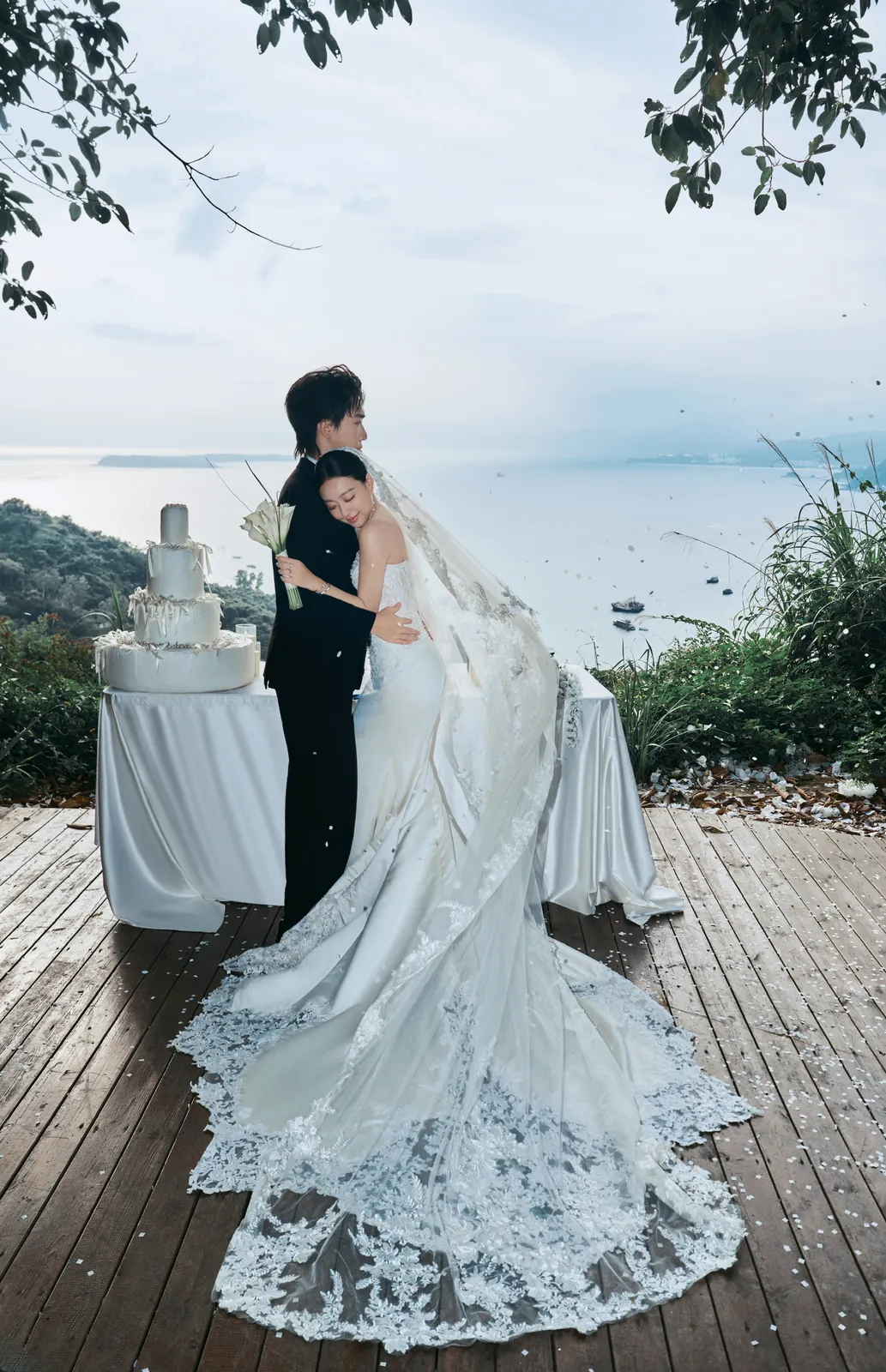 新人在湖边布景前相拥的婚纱照